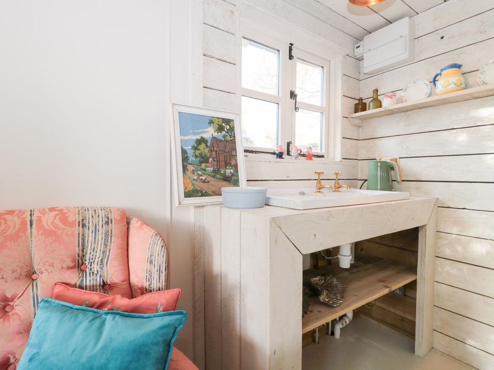A kitchen with a sink and a painting at Shades Farm Cabin in Cirencester