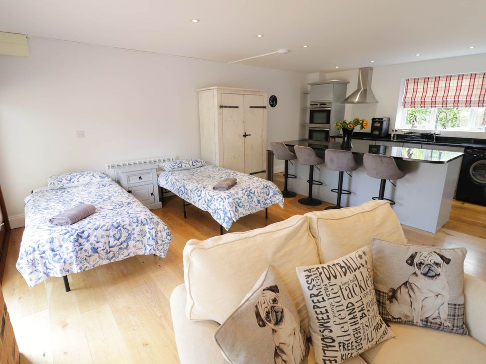 A living room with beds and a kitchen area at Underhill House Annex