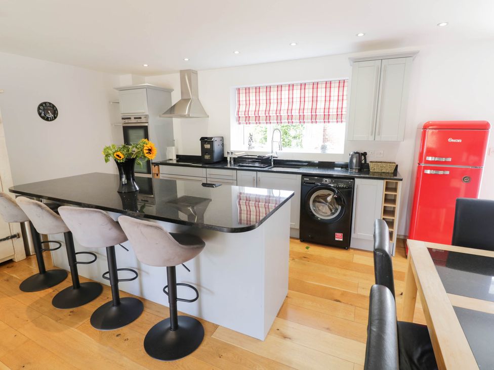 A kitchen with a black countertop and red refrigerator at Underhill House Annex