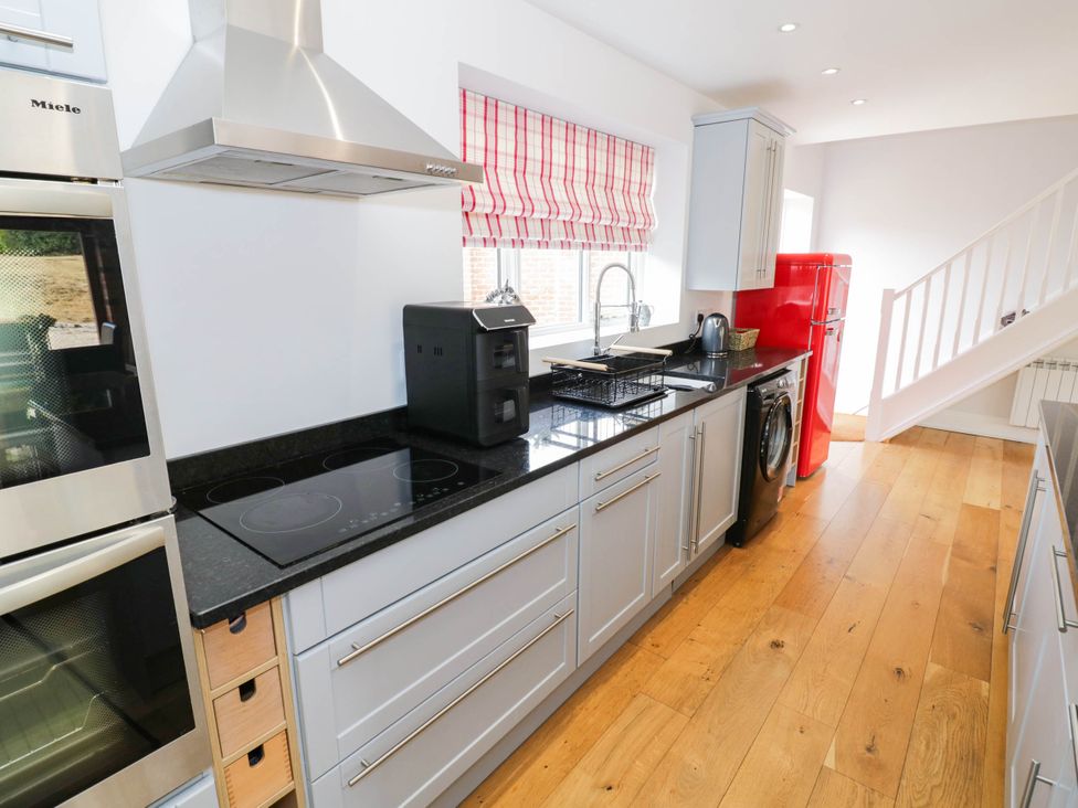 A kitchen with appliances and cabinetry at Underhill House Annex