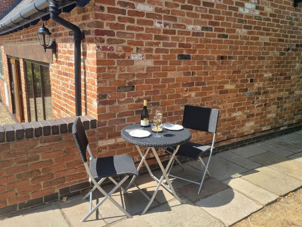 An outdoor dining area with a table and two chairs at Underhill House Annex Stratford-Upon-Avon