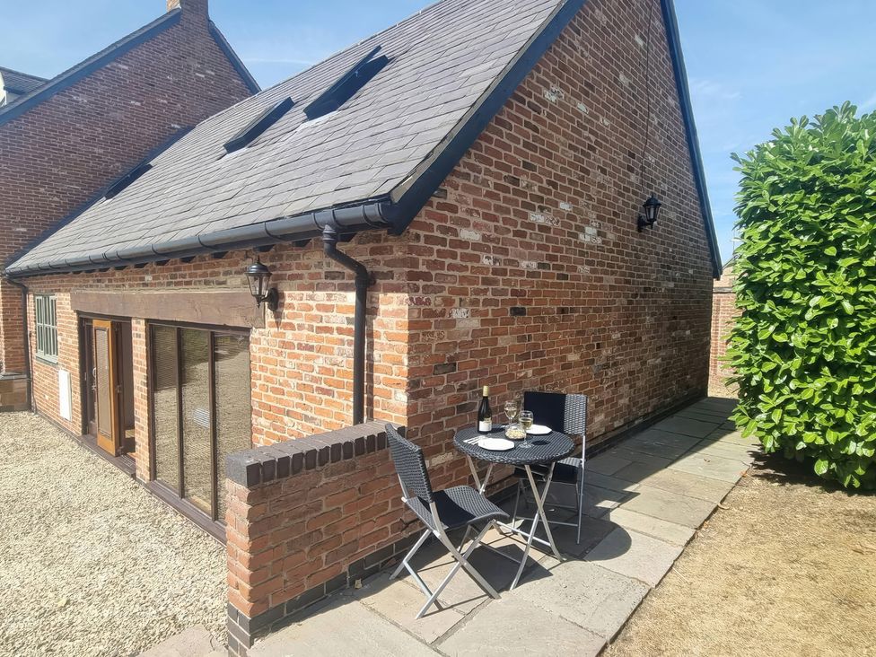 An outdoor seating area with a table and chairs at Underhill House Annex Stratford-Upon-Avon