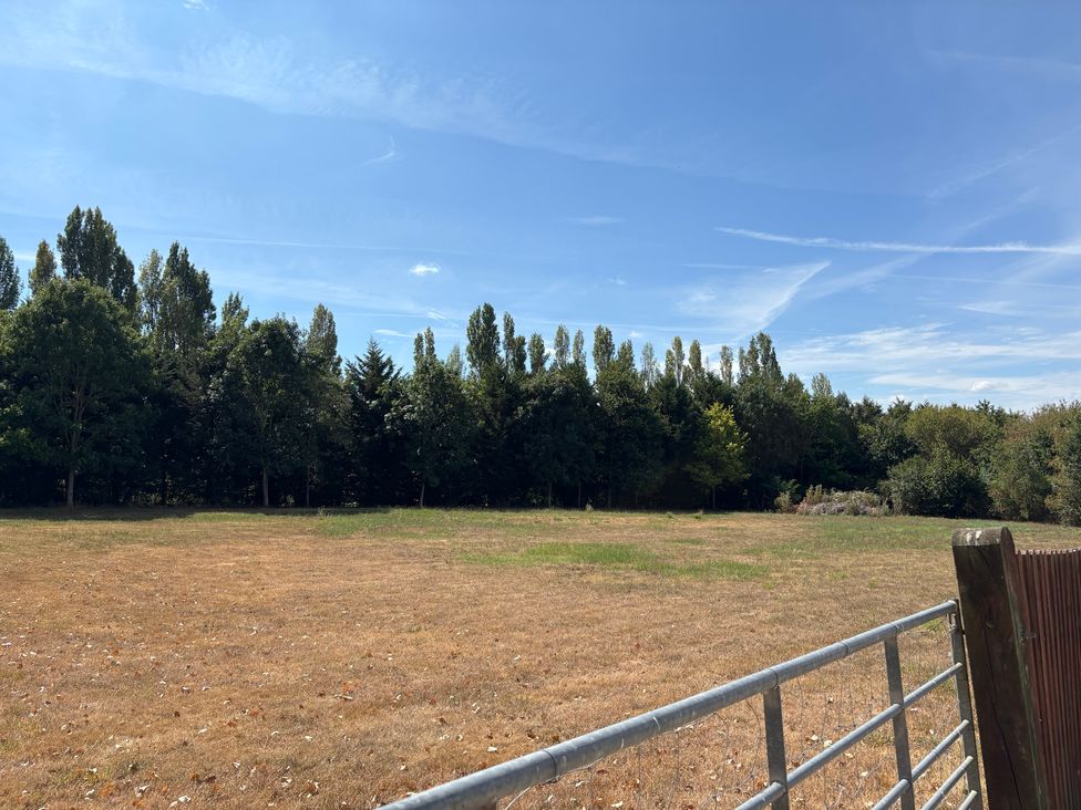 A field with a gate and trees at Underhill House Annex Stratford-Upon-Avon