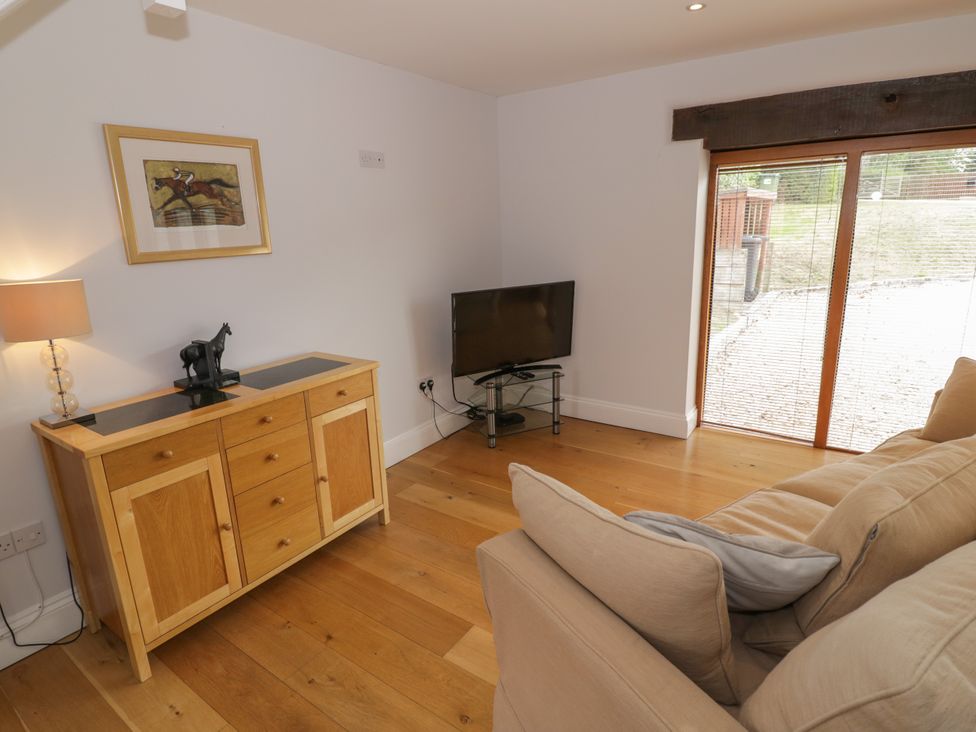 A living room with a television and a cabinet at Underhill House Annex Stratford-Upon-Avon