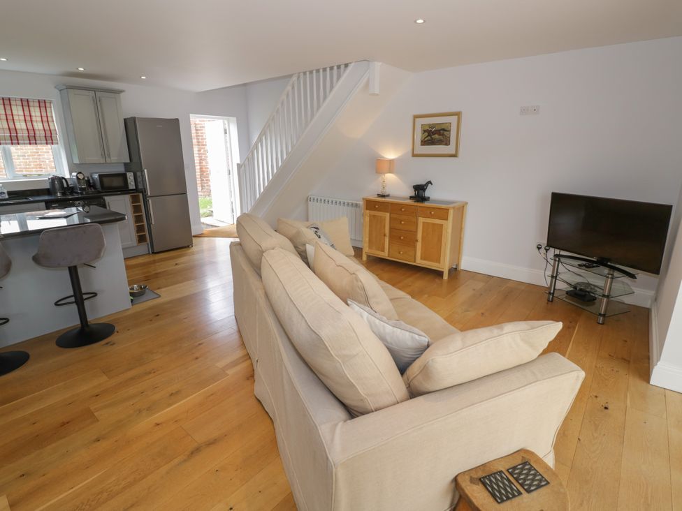 A living room with a sofa and kitchen area at Underhill House Annex Stratford-Upon-Avon