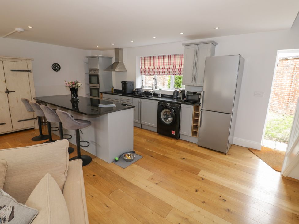 A kitchen with appliances and seating area at Underhill House Annex Stratford-Upon-Avon