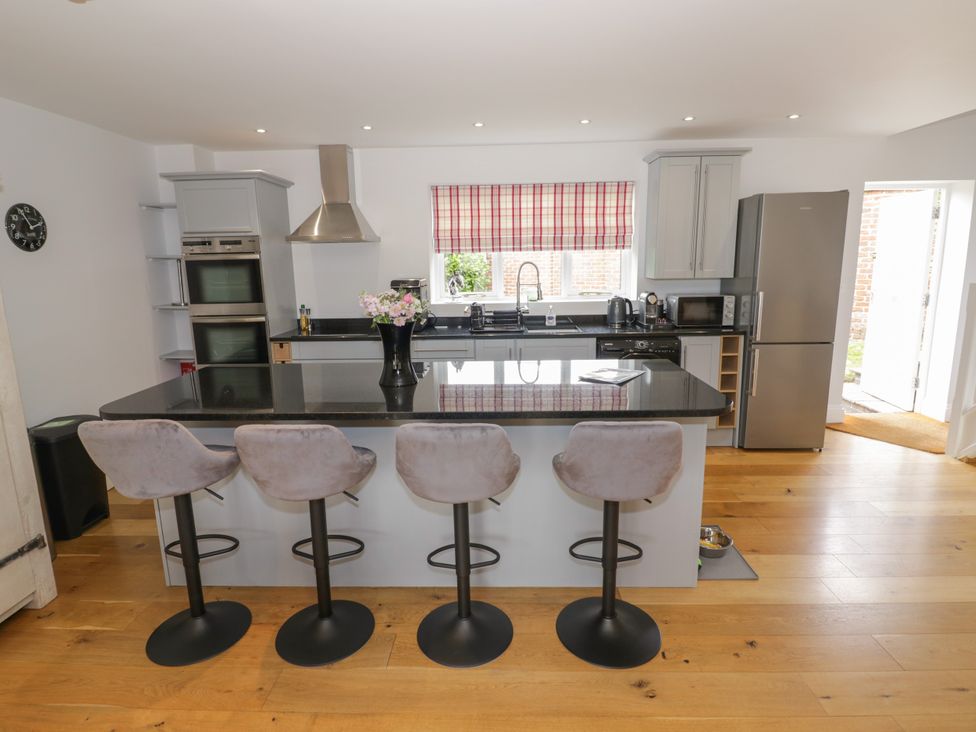 A kitchen with an island and bar stools at Underhill House Annex Stratford-Upon-Avon