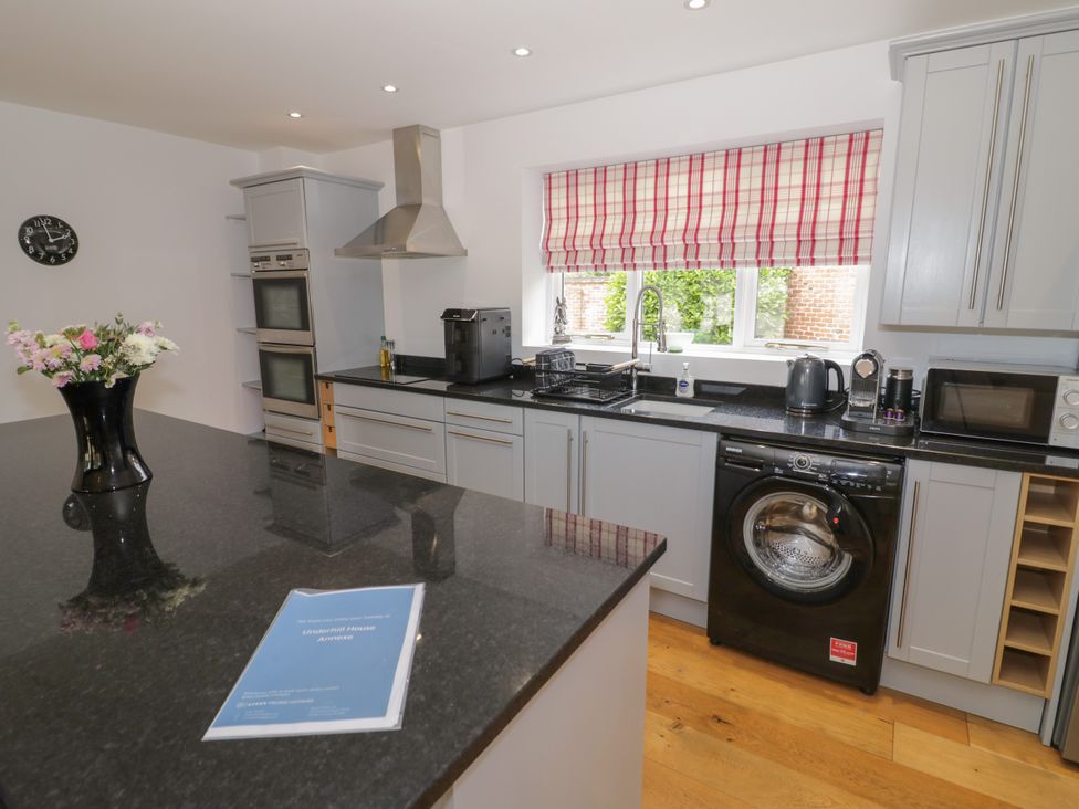 A kitchen with appliances and a vase of flowers at Underhill House Annex Stratford-Upon-Avon