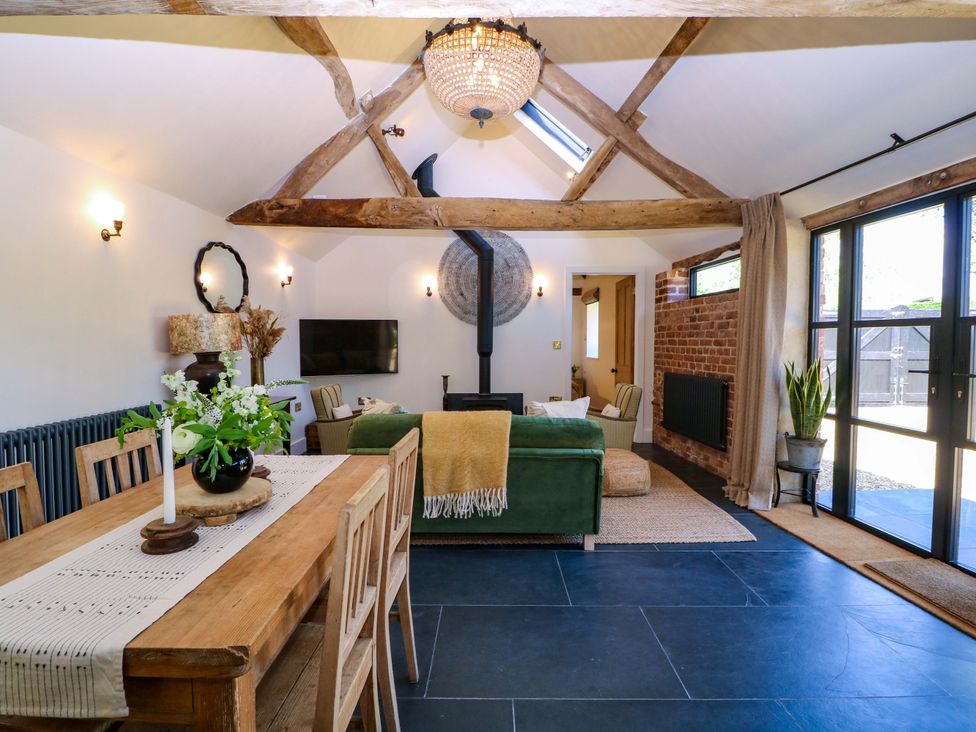 A living room with a dining area and sofa at The Barn in 