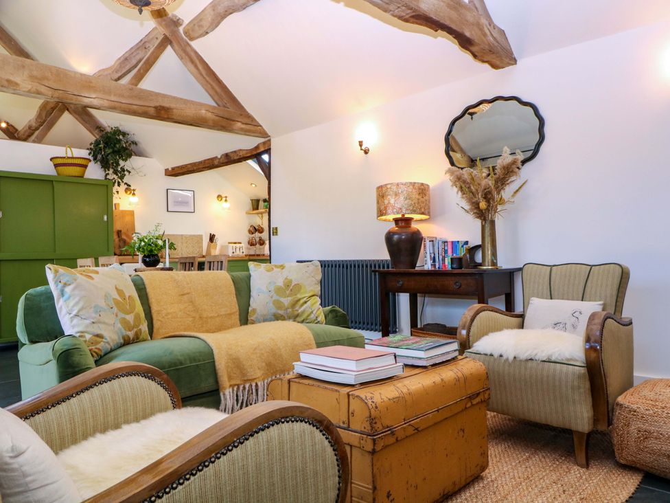 A living room with a sofa, armchair and coffee table at The Barn in 