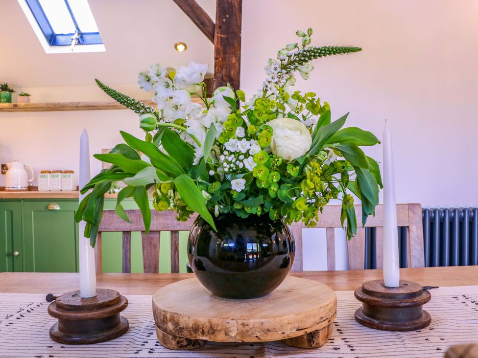 A flower arrangement on a wooden platter with candlesticks at The Barn in 