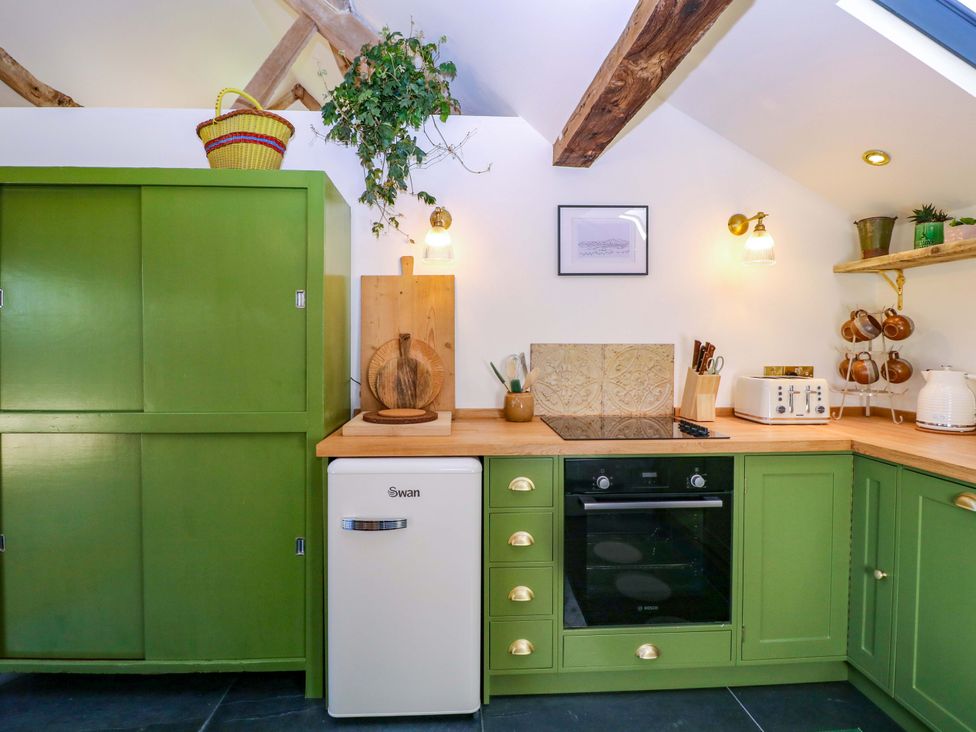 A kitchen with a refrigerator and oven in The Barn