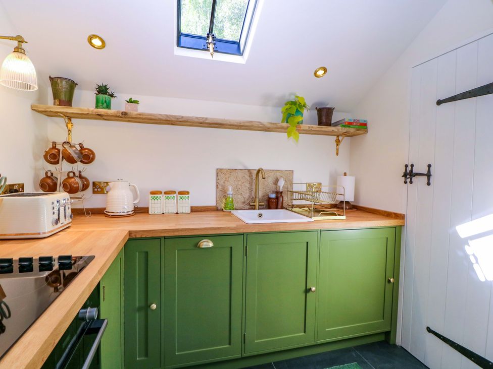 A kitchen with cabinets, sink, and shelves at The Barn in 