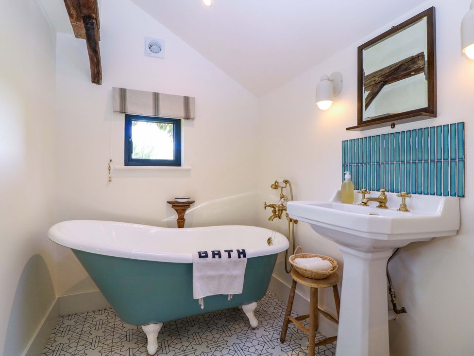 A bathroom with a bathtub and sink at The Barn 