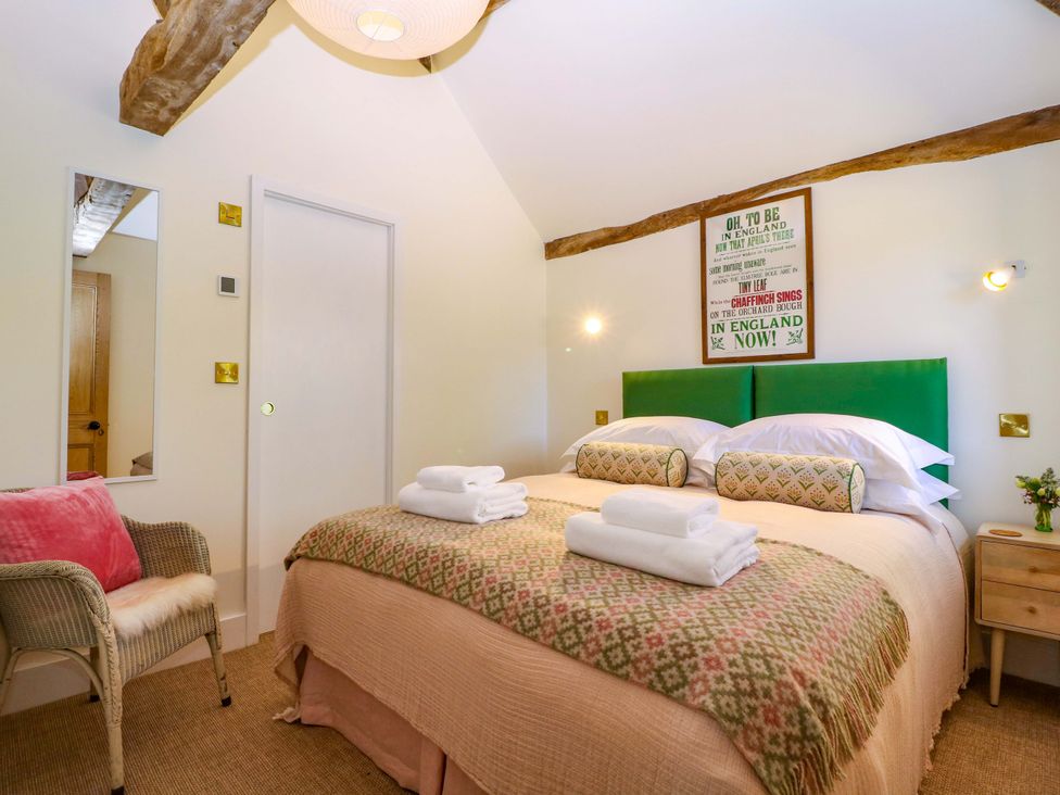A bedroom with a double bed and side table at The Barn in 