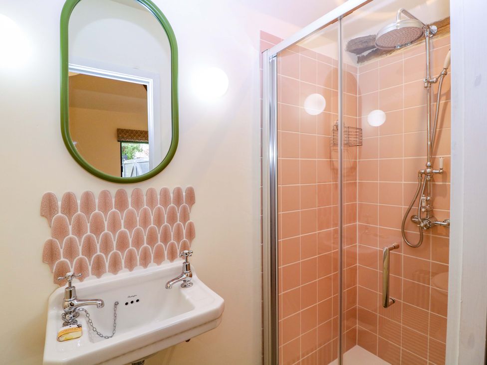 A bathroom with shower, sink, and mirror at The Barn in 