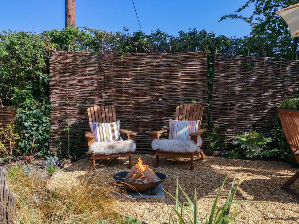 A garden with chairs and a fire pit at The Barn 