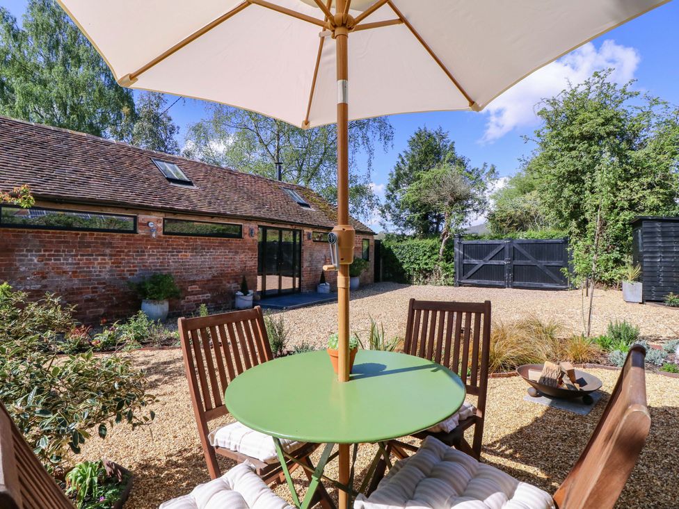 A garden with a table and chairs under an umbrella at The Barn 