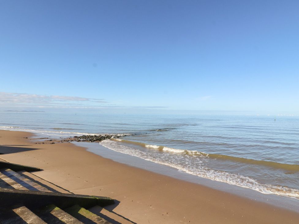 A beach with sand and ocean waves at 6 Bastion Close Prestatyn