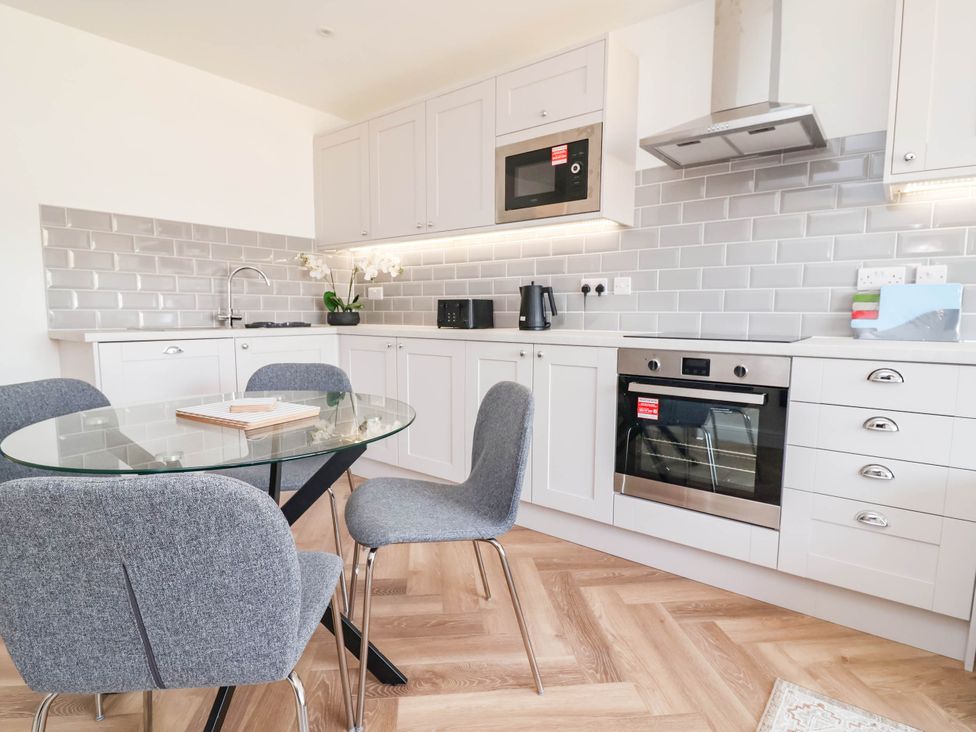 A kitchen with a table and chairs at 6 Bastion Close in Prestatyn