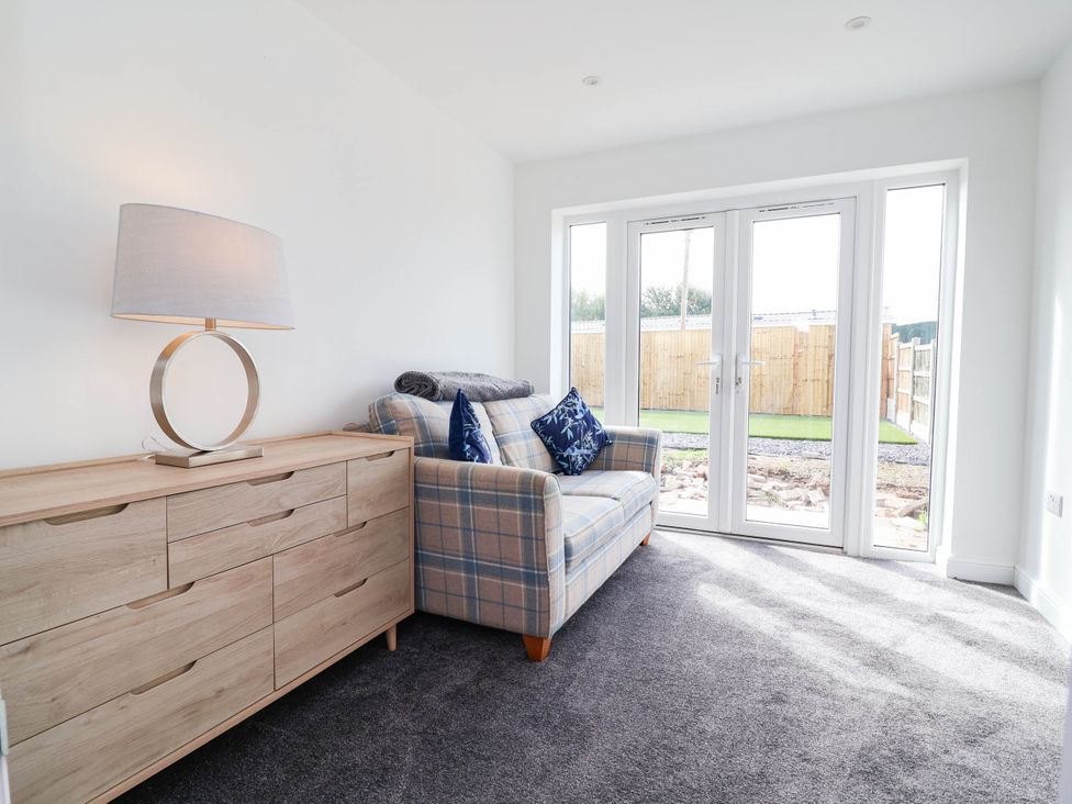 A snug with a sofa and sideboard at 6 Bastion Close Prestatyn