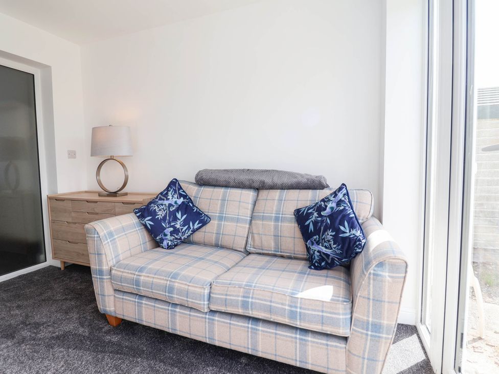 A living room with a sofa and lamp at 6 Bastion Close Prestatyn