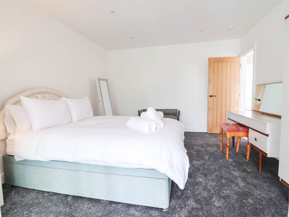 A bedroom with a bed and dressing table at 6 Bastion Close Prestatyn