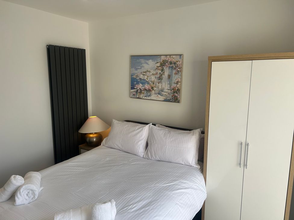 A bedroom with a bed and wardrobe at 6 Bastion Close in Prestatyn