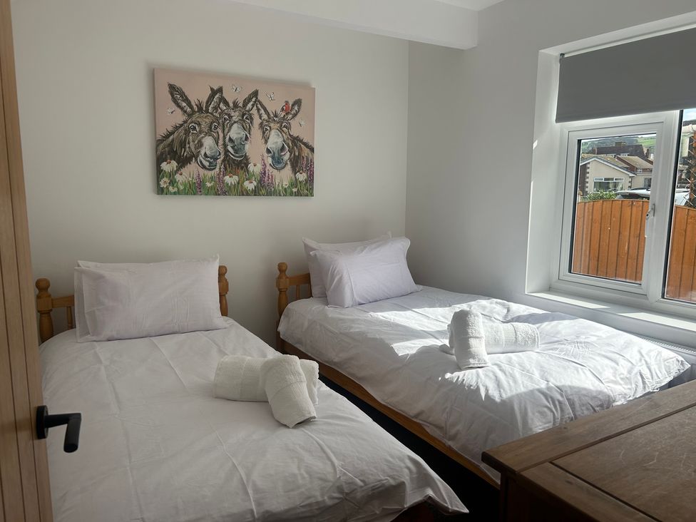 A bedroom with two beds and a window at 6 Bastion Close, Prestatyn