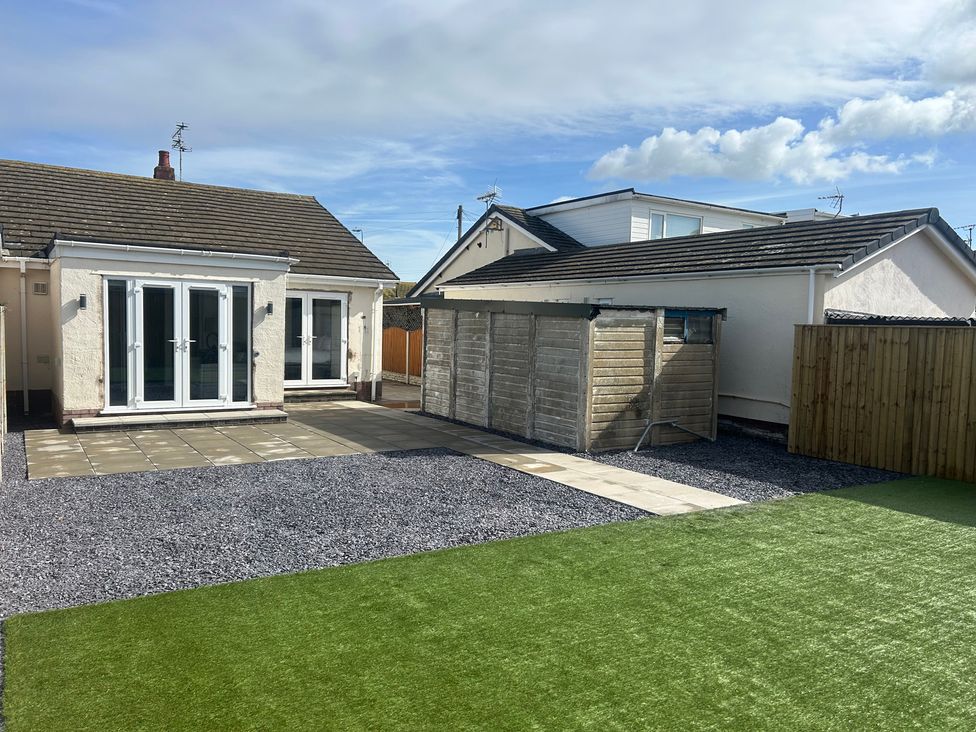 A garden with a house and shed at 6 Bastion Close in Prestatyn