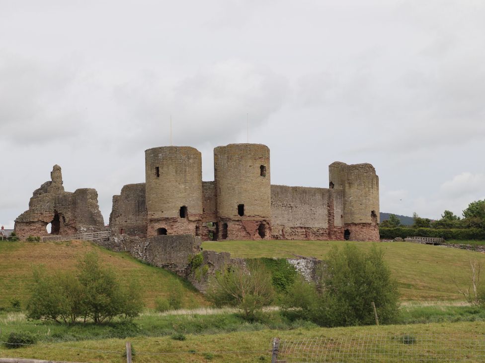 A castle with towers and ruins set in a grassy area