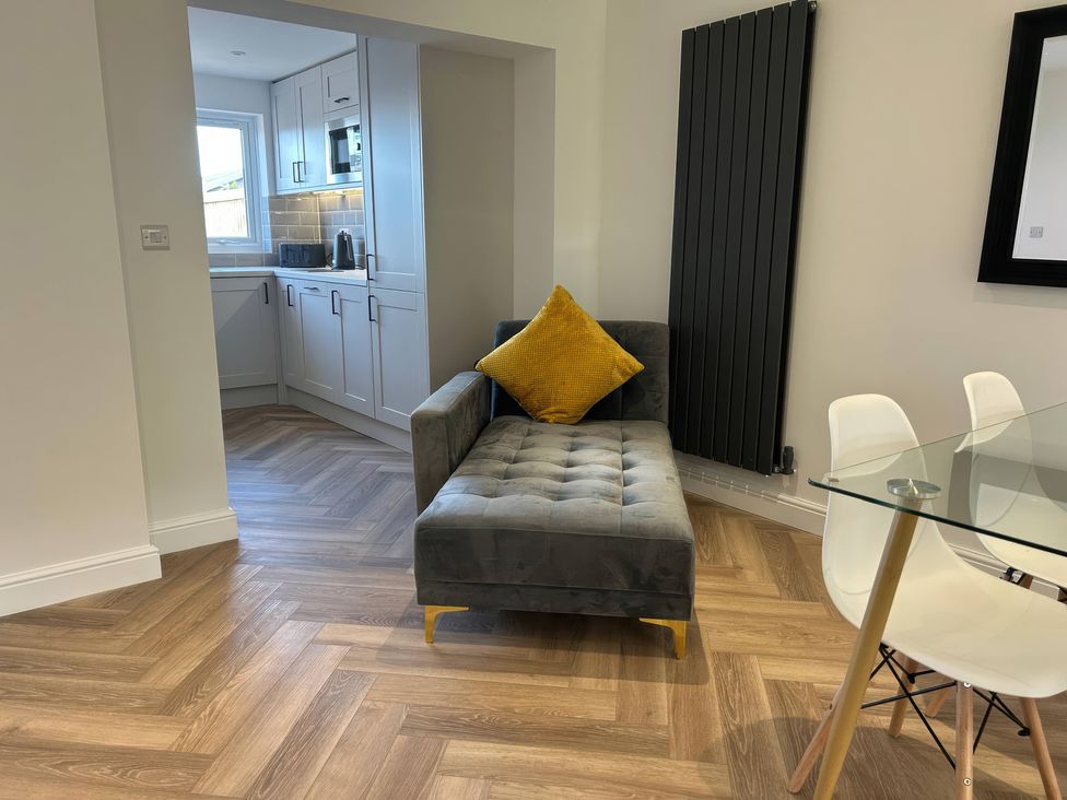 A living room with a sofa and dining area at 21 Bastion Gardens Prestatyn