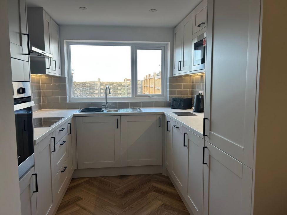 A kitchen with cabinets and appliances at 21 Bastion Gardens Prestatyn