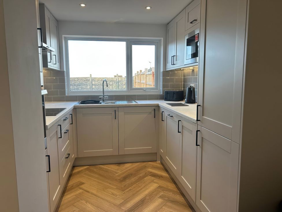 A kitchen with cabinets and a sink at 21 Bastion Gardens in Prestatyn