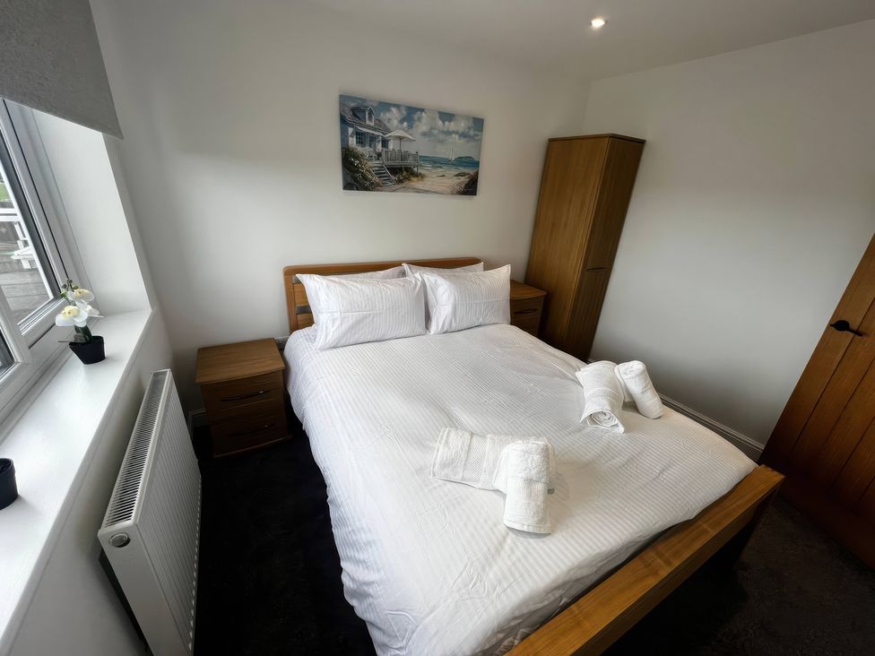 A bedroom with a bed and nightstand at 21 Bastion Gardens Prestatyn