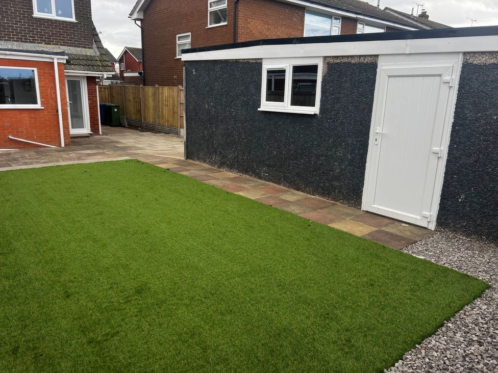 A garden with a lawn and a shed at 21 Bastion Gardens Prestatyn