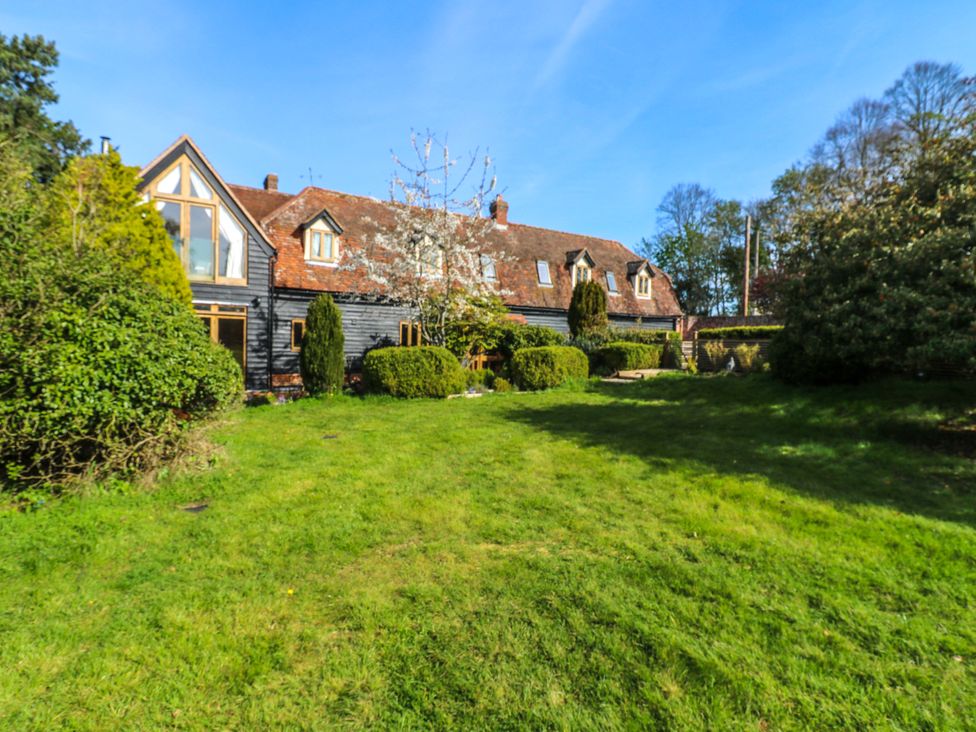 A garden with a house in the background at Six Apples Wethersfield near Finchingfield