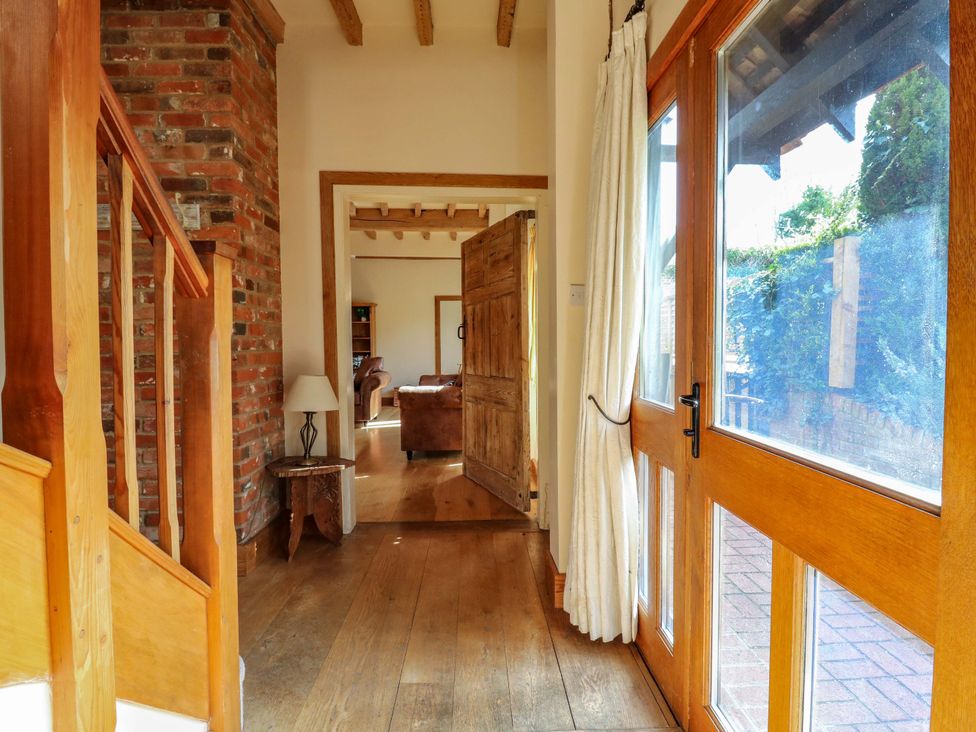 A hallway with a staircase and a door at Six Apples in Wethersfield near Finchingfield