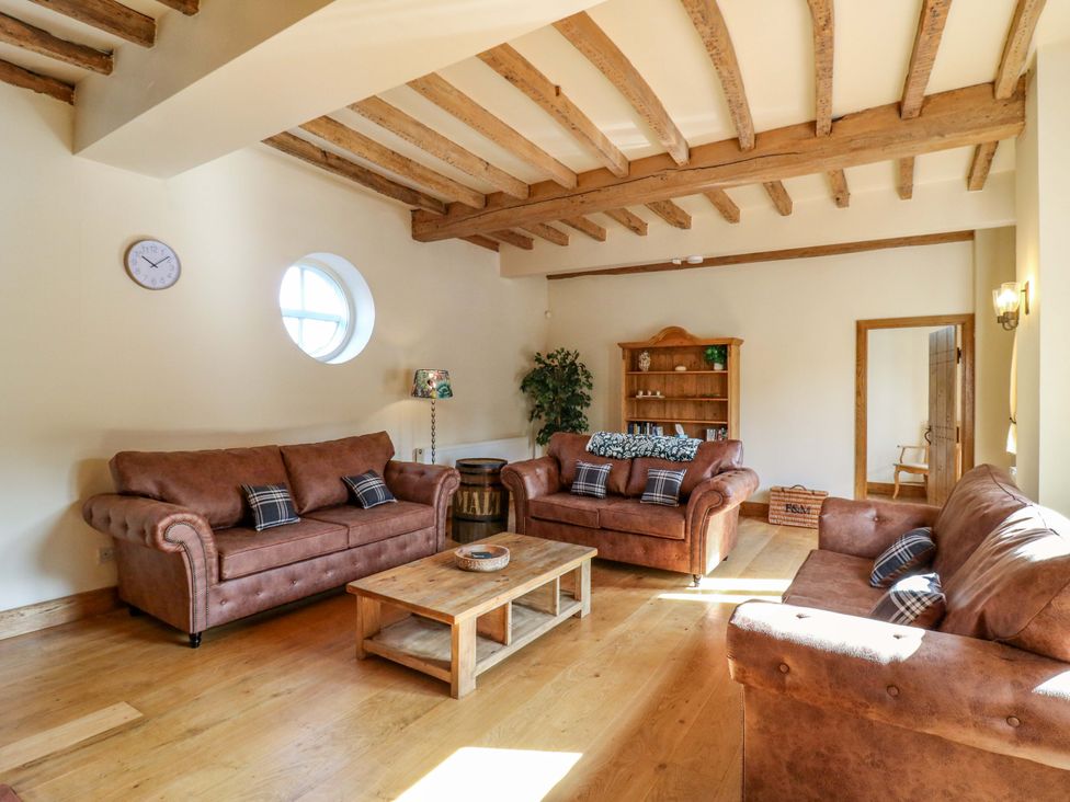 A living room with sofas and a coffee table at Six Apples in Wethersfield near Finchingfield
