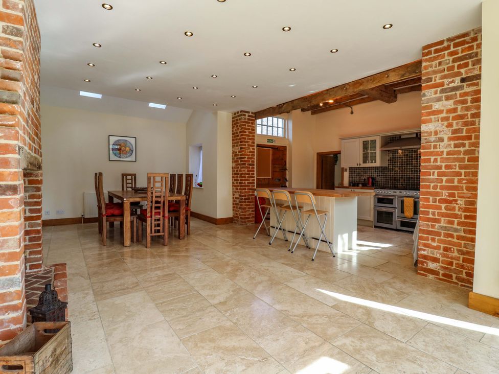 A kitchen with a dining area and bar stools at Six Apples in Wethersfield near Finchingfield
