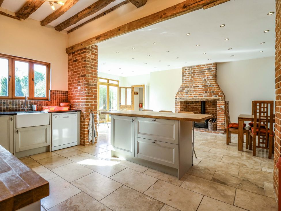 A kitchen with an island and a fireplace at Six Apples in Wethersfield near Finchingfield