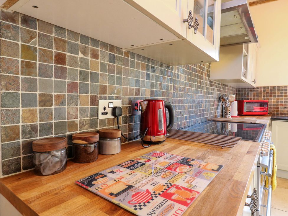A kitchen with a kettle and storage jars at Six Apples Wethersfield near Finchingfield