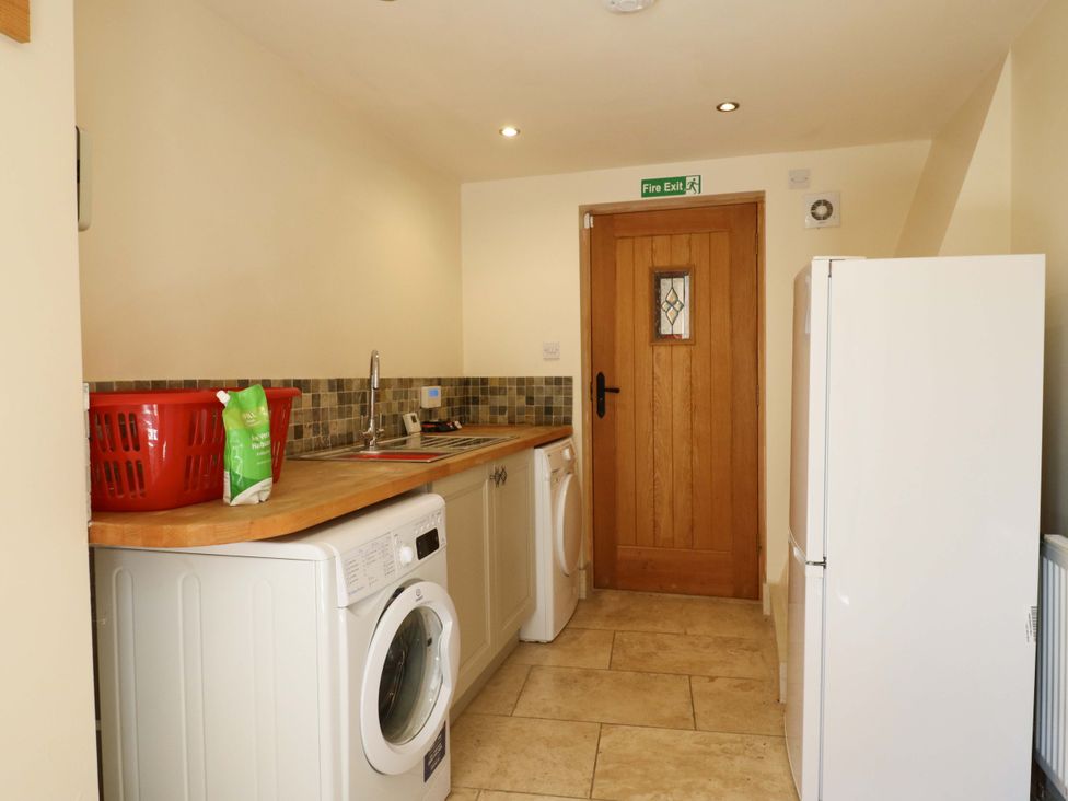 A laundry room with washing machine, drying machine, sink and refrigerator at Six Apples near Wethersfield