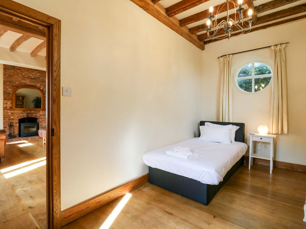 A bedroom with a bed and nightstand at Six Apples Wethersfield near Finchingfield