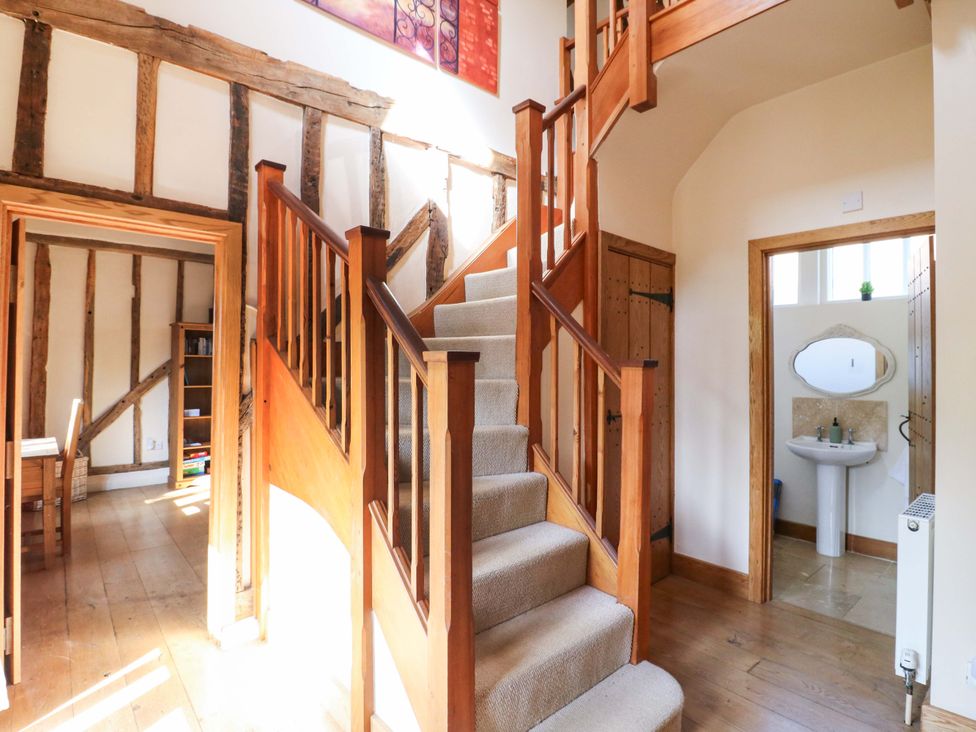 A hallway with a staircase and a sink at Six Apples in Wethersfield near Finchingfield