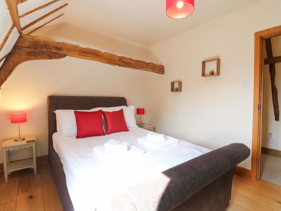 A bedroom with a bed and bedside table at Six Apples in Wethersfield near Finchingfield