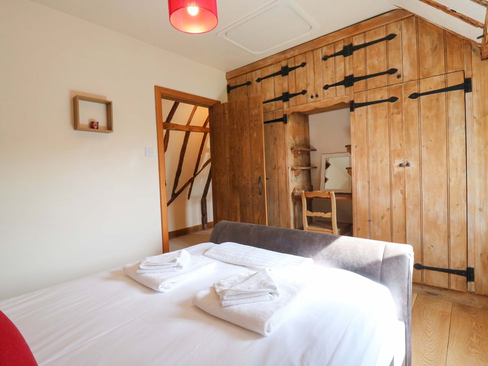 A bedroom with a bed and wardrobe at Six Apples Wethersfield near Finchingfield