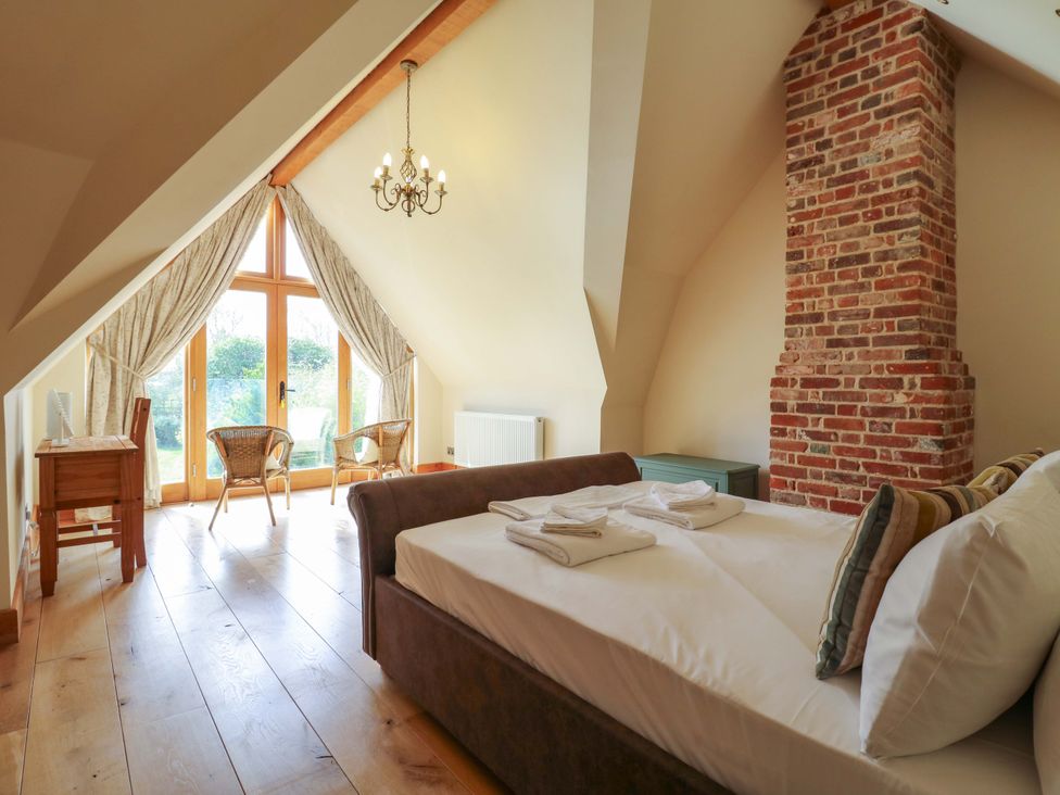 A bedroom with a bed and desk at Six Apples in Wethersfield near Finchingfield