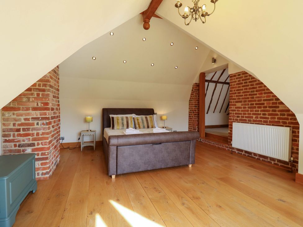 A bedroom with a bed and nightstand at Six Apples in Wethersfield near Finchingfield
