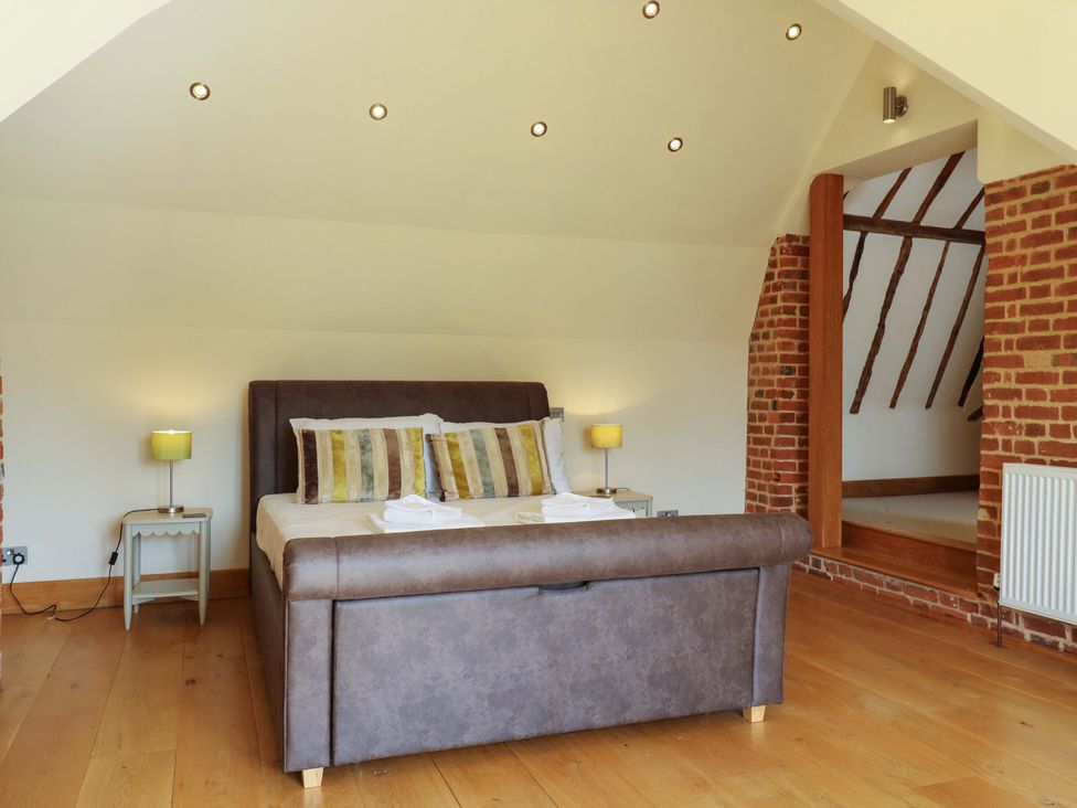A bedroom with a bed and bedside lamp at Six Apples, Wethersfield near Finchingfield